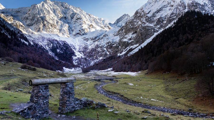 Prado verde y montañas del Valle de Arán en un día despejado